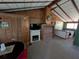 Cozy living area showcasing a decorative fireplace, wood paneling, and a quaint dining table set at 14830 Se 61St Street Rd, Ocklawaha, FL 32179