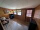 Cozy living room featuring paneled walls, tile floors, and natural light from the windows at 14830 Se 61St Street Rd, Ocklawaha, FL 32179