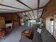 Inviting living room with a comfortable couch, wood paneling, decorative fireplace, and open access to the kitchen at 14830 Se 61St Street Rd, Ocklawaha, FL 32179