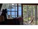 Cozy screened-in porch featuring comfortable seating and picturesque views of the serene lake and natural surroundings at 14830 Se 61St Street Rd, Ocklawaha, FL 32179