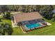 Screened-in pool is complemented by a well-manicured lawn and beautiful landscaping at 19009 Sw 98Th Loop, Dunnellon, FL 34432