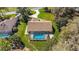 A backyard features a screened in pool, and adjoins a lush green manicured lawn at 19009 Sw 98Th Loop, Dunnellon, FL 34432