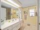 Bright bathroom with single sink vanity, tiled floors, and a walk-in shower at 19009 Sw 98Th Loop, Dunnellon, FL 34432