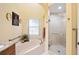 Bathroom featuring a walk-in shower, jacuzzi tub, and natural lighting at 19009 Sw 98Th Loop, Dunnellon, FL 34432