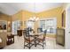 Cozy dining area with a glass-top table, chandelier, and bright natural lighting at 19009 Sw 98Th Loop, Dunnellon, FL 34432