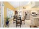 Bright dining area featuring a glass-top table and chairs with an adjacent kitchen view at 19009 Sw 98Th Loop, Dunnellon, FL 34432