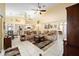 Inviting living room featuring plush seating, a ceiling fan, and an open layout to the kitchen at 19009 Sw 98Th Loop, Dunnellon, FL 34432