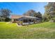 Lush backyard featuring a screened-in pool, well-maintained lawn, and meticulous landscaping at 19009 Sw 98Th Loop, Dunnellon, FL 34432