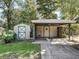 View of the detached carport and storage shed, surrounded by green landscaping at 2605 Ne 14Th Ave, Ocala, FL 34470