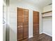 Bedroom closet with shelving and two wooden louvered doors at 2605 Ne 14Th Ave, Ocala, FL 34470