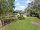 Exterior angle showcasing the home, carport, and the expansive, well-maintained lawn at 2605 Ne 14Th Ave, Ocala, FL 34470