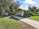 Cozy home showcasing a metal roof, a carport, and mature landscaping at 2605 Ne 14Th Ave, Ocala, FL 34470