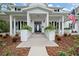 White farmhouse exterior with a large front porch and landscaping at 2704 Se 31St St, Ocala, FL 34471