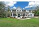 Two-story white farmhouse with large front porch and American flag at 2704 Se 31St St, Ocala, FL 34471