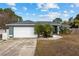 Single-story home with gray exterior, white garage door, and landscaping at 35 Teak Rd, Ocala, FL 34472