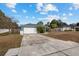 Single story home with gray siding, white garage door, and long driveway at 35 Teak Rd, Ocala, FL 34472