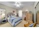 Cozy bedroom with a ceiling fan, complemented by a serene blue and white striped bed set at 7066 Sw 91St Ct, Ocala, FL 34481