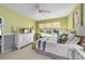 Light-filled bedroom showcasing green walls, a queen bed, white dresser, and a ceiling fan at 7066 Sw 91St Ct, Ocala, FL 34481