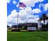 Del Webb Stone Creek community entrance featuring landscaped grounds, flagpole and blue skies in the background at 7066 Sw 91St Ct, Ocala, FL 34481