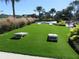 Well-maintained cornhole area with landscaping and a covered seating area in the background at 7066 Sw 91St Ct, Ocala, FL 34481