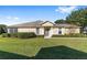 Tan house with manicured lawn and shrubs at 7066 Sw 91St Ct, Ocala, FL 34481