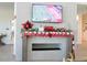 Festive fireplace featuring stockings, holiday decor, and a large-screen TV displaying a football game in a welcoming space at 7066 Sw 91St Ct, Ocala, FL 34481