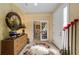 Inviting foyer featuring tile floors, decorative mirror, and an open doorway at 7066 Sw 91St Ct, Ocala, FL 34481