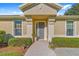 Inviting front entrance with decorative pillars, beautiful landscaping, and a well-maintained walkway at 7066 Sw 91St Ct, Ocala, FL 34481