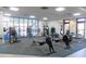 Bright gym featuring exercise equipment, large windows overlooking the pool, and a mirrored wall at 7066 Sw 91St Ct, Ocala, FL 34481