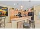 Inviting kitchen featuring a breakfast bar, stylish pendant lights, wooden cabinetry, and a decorative wine themed poster at 7066 Sw 91St Ct, Ocala, FL 34481