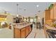 Open kitchen showcasing pendant lights over the island, seamlessly connected to the living area and outdoor patio at 7066 Sw 91St Ct, Ocala, FL 34481