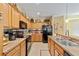 Well-lit kitchen with wooden cabinets, black appliances, and stylish backsplash, offering a functional and aesthetically pleasing space at 7066 Sw 91St Ct, Ocala, FL 34481