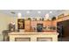 A cozy kitchen featuring pendant lighting, wooden cabinets, a black refrigerator, and a decorative arrangement above the cabinets at 7066 Sw 91St Ct, Ocala, FL 34481