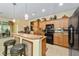 Kitchen with island, wood cabinets, and black appliances at 7066 Sw 91St Ct, Ocala, FL 34481