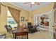 Cozy home office with a large wooden desk, leather chair, and serene backyard views at 7066 Sw 91St Ct, Ocala, FL 34481