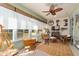 Cozy sunroom with wicker furniture, a ceiling fan, and views of the landscaped yard at 7066 Sw 91St Ct, Ocala, FL 34481