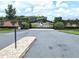 Gated entrance to a community with a paved road and lush landscaping at 7403 Ne 22Nd Court Rd, Ocala, FL 34479