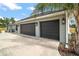 Two-car garage with dark gray doors and exterior lights at 7403 Ne 22Nd Court Rd, Ocala, FL 34479