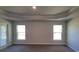 Main bedroom with carpet, tray ceiling and multiple windows at 7587 Sw 103Rd Loop, Ocala, FL 34476