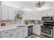 Bright white kitchen features ample cabinetry, stainless steel appliances, and a corner sink at 8625 Sw 94Th Ln # G, Ocala, FL 34481