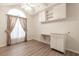 Bedroom with wood-look floors, window, and built-in cabinets at 2444 Se 18Th Cir, Ocala, FL 34471