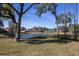 Serene pond view with mature trees and residential homes in background at 2444 Se 18Th Cir, Ocala, FL 34471