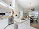 Well-lit kitchen with a kitchen island, white cabinets, and stainless steel appliances at 9805 Sw 190Th Terrace Rd, Dunnellon, FL 34432