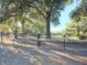 Community dog park featuring a chain-link fence, play areas, and mature trees for shade at 10975 Sw 69Th Cir, Ocala, FL 34476