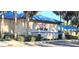 A beautiful view of the Orchid Club with tropical landscaping, with a stone facade, and a metal roof at 10975 Sw 69Th Cir, Ocala, FL 34476
