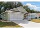 House exterior showcasing a two-car garage and well-manicured lawn at 10975 Sw 69Th Cir, Ocala, FL 34476