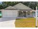 House exterior featuring a covered porch and a two-car garage at 10975 Sw 69Th Cir, Ocala, FL 34476