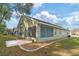 Rear view of the house with a screened-in patio and lush landscaping at 10975 Sw 69Th Cir, Ocala, FL 34476