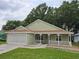 Inviting single-story home with a charming front porch, manicured lawn, and a convenient two-car garage at 10975 Sw 69Th Cir, Ocala, FL 34476