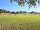The golf course driving range with a lush green field surrounded by trees, ideal for golfers of all skill levels at 10975 Sw 69Th Cir, Ocala, FL 34476